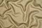 Golden woolen crumpled wrinkled fabric with waves