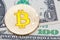 Golden yellow bitcoin on different dollar banknotes background.