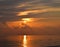 Golden Yellow Shining Sun Rising at Horizon with Reflection in Sea Water with Bright Colors in Sky