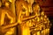 Golden yellow statue of Buddha standing meditating and praying