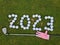 Golf 2023 New Year number with golf ball on grass field relief of a sports club