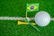 Golf ball with Brazil flag and tee on green lawn or grass is most popular sport in the world