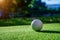 Golf ball on fairway of beautiful golf course at summer sunset