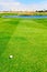 Golf ball on fairway with water hazard in front of green