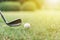 Golf ball with golf club on green grasses with sunlight.