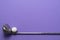 Golf ball and golf club on purple background, sport concept