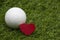 Golf ball is on green grass on valentine day