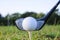 A golf ball is placed on the grass with a mountain view behind