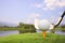 A golf ball is placed on the grass with a mountain view behind