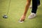 Golf ball, putter and boy\'s legs on green