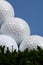 Golf Ball Pyramid on grass against blue sky