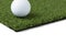 Golf Ball Resting on Section of Artificial Turf Grass On White Background