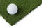 Golf Ball Resting on Section of Artificial Turf Grass On White Background