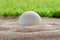 Golf ball in sand bunker near the lawn