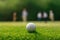 Golf Ball on Tee with Anticipating Golfers in Blurred Background