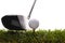 Golf ball on tee in grass with driver