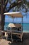 Golf cart on beach at tropical island resort hotel