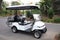 A golf cart car parked at a road in a garden golf course