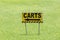 The golf carts sign on a golf field for the direction with blurred natural green grass on background.