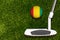 A golf club and a ball with flag Guinea during a golf game