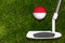 A golf club and a ball with flag Monaco during a golf game