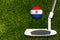 A golf club and a ball with flag Paraguay during a golf game