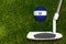 A golf club and a ball with flag Salvador during a golf game