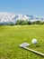 Golf club and golf ball on the turf with Mount Rosa in the background