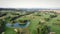 Golf course, aerial view. Flying over green golf field with small lake and green trees. Sport recreation concept. Leisure activity