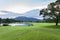 Golf course green grass field with mountain tropical forest.