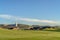 Golf course overlooking rooftops church steeple and mountain on a sunny day