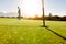 Golf hole and flag in the green field with golfer