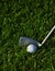 Golf iron and ball in grass