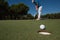 Golf player hitting shot, ball on edge of hole