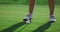 Golf player legs stand at golf course grass. Woman swinging golfing shot outside