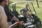 Golf player talking to his friends while sitting in golf cart on golf course