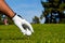 Golf player with tee and golf ball on course. Golfer with golf club taking a shot. Golfer mans hand with golf glove.