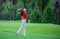 Golf player teeing off. Woman hitting golf ball from tee box with driver