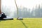 Golf player women at the putting green hitting ball into a hole in holiday sunny day.