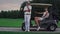 Golf players sit cart on course. Sport couple enjoy activity in driving golf car