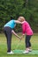 Golf pro teaching a lady golfer