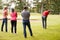 Golf Professional Demonstrating Shot On Fairway To Group Of Golfers During Lesson