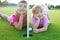 Golf sister girls relaxed laying green hole ball