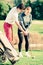 Golf trainer teaches a woman game