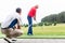 Golf trainer working with golf player on driving range