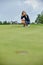 Golfer action to win after a long game of golf on a green field. The girl is playing golf. Golf concept, hole