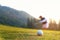 Golfer asian woman focus putting golf ball on the green golf on sun set evening time