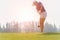 Golfer asian woman putting golf ball on the green golf on sun set evening time.