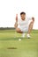 Golfer crouching and eyeing up putt