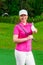 Golfer happy woman standing with a golf club